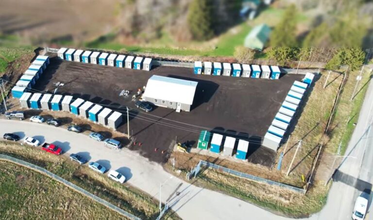 An aerial photo of the Erbs Road Shelter site shows 50 cabins and a large community building