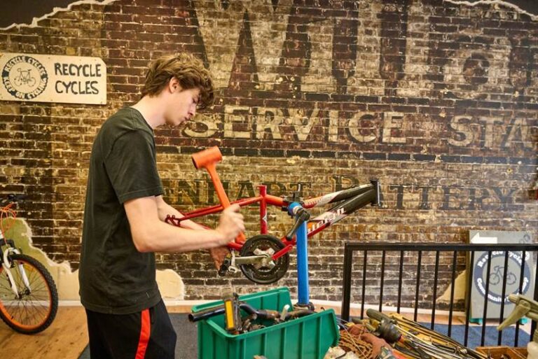 A man works on a bicycle inside the Recycle Cycles shop