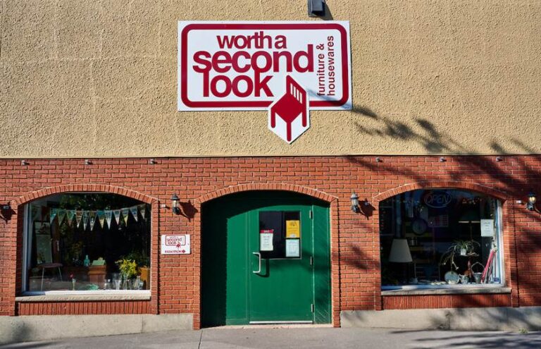 A brick building with a green entry door between large windows at 37 Market Lane, the Worth A Second Look store entrance